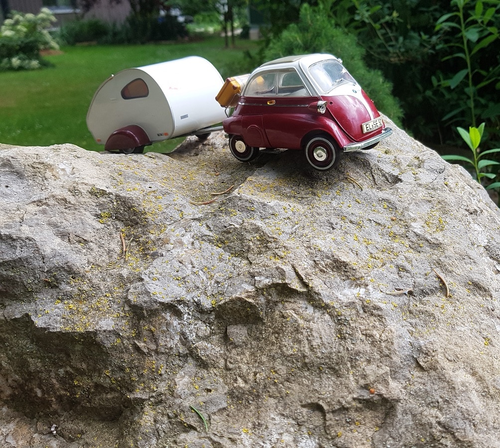 Miniaturauto mit Wohnwagen als Symbol für den Stellplatz der Schäferei Engel